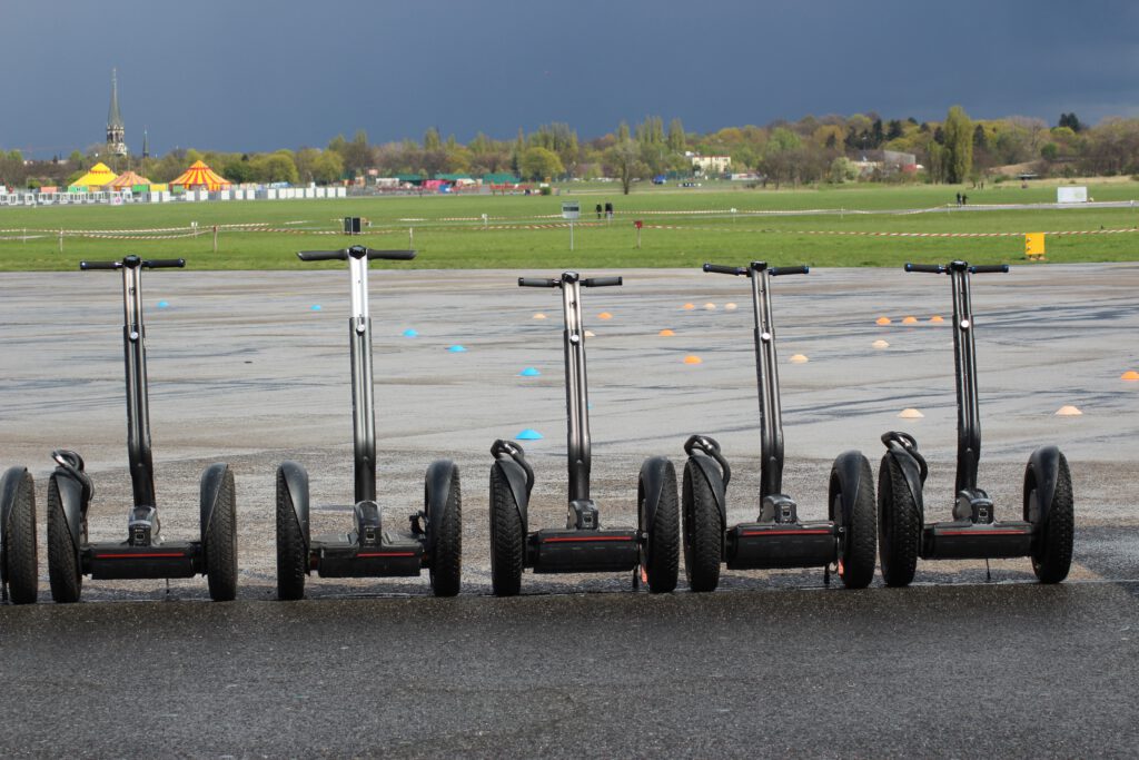 Segway - segwaye różnej wielkości stoją na asfalcie