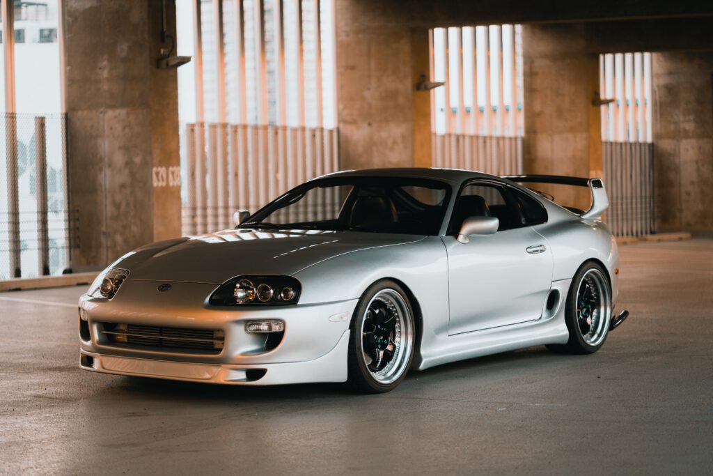 Biały samochód Toyota Supra stoi na parkingu w budynku.