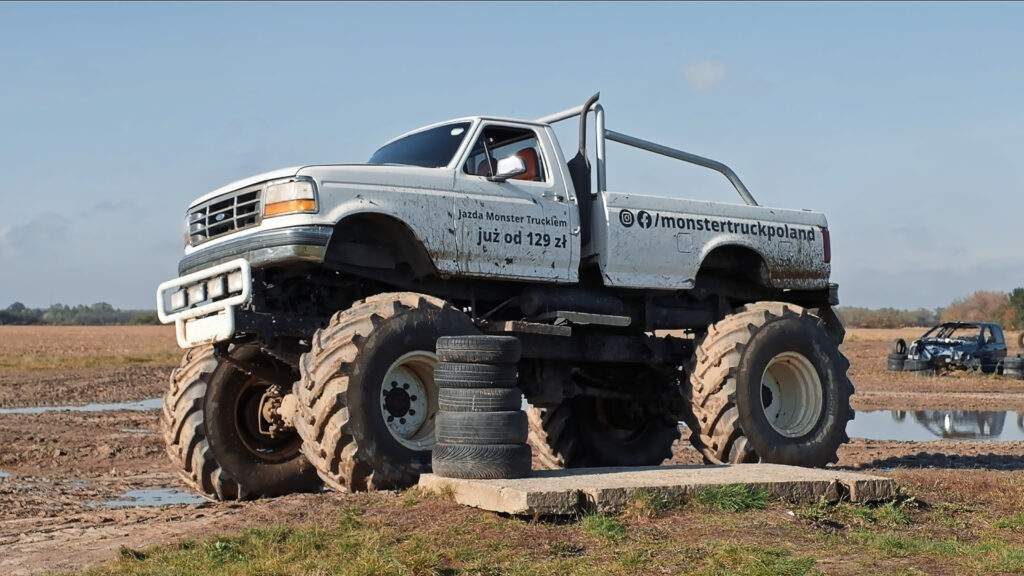 Biały Monster Truck, widziany z boku, gotowy do przejazdu