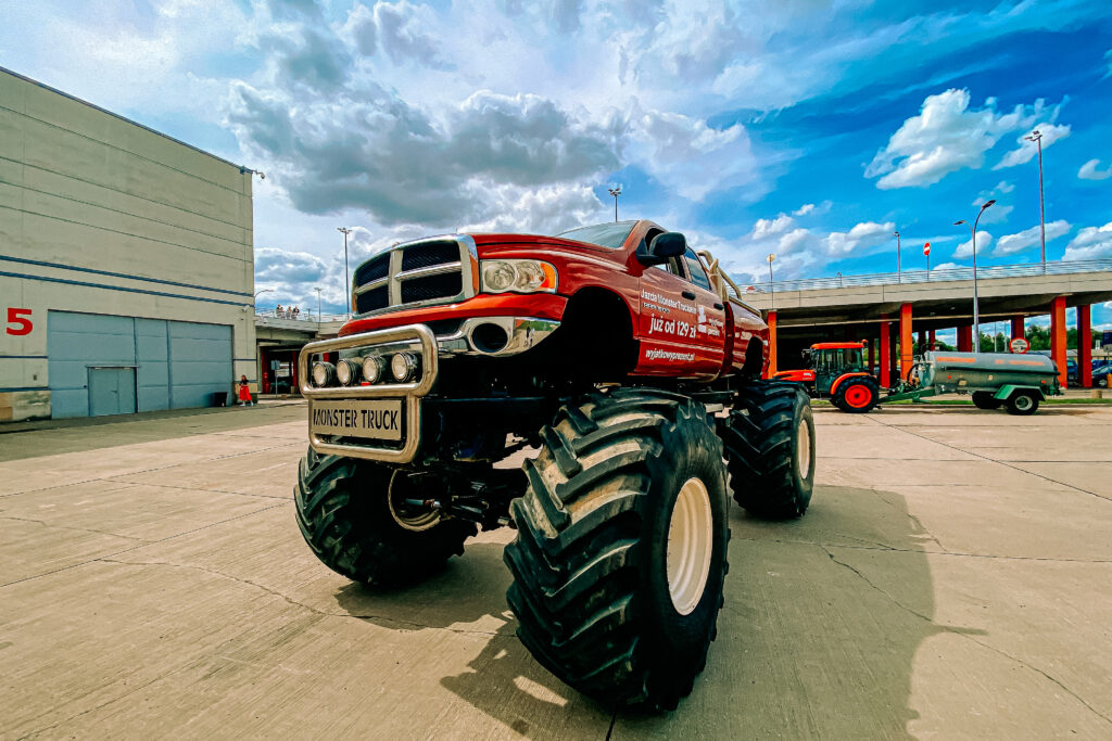 Jazda Monster Truck - czerwony Monster Truck na ulicy w mieście - widok z przodu